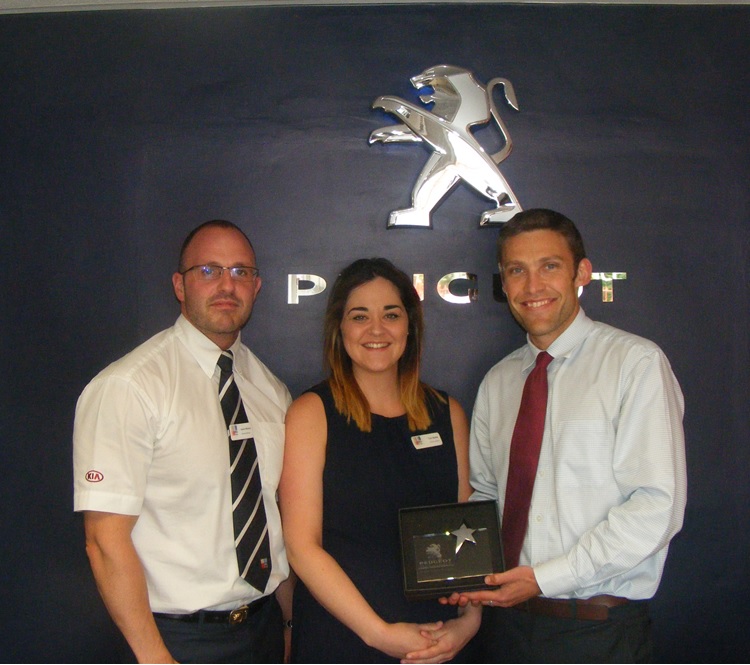 RRG Peugeot Bury employee Toni Baillie receiving his award